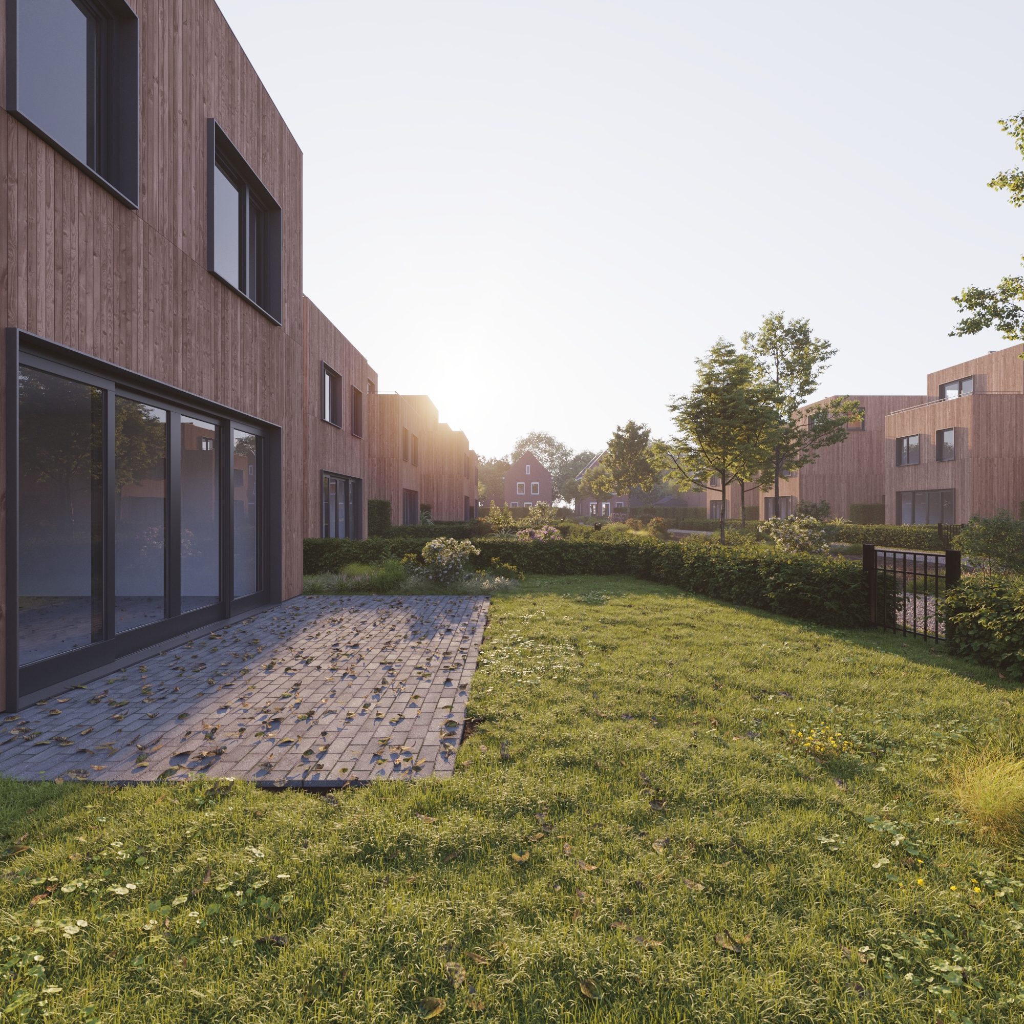 Tuin met terras bij houten woning in avondlicht